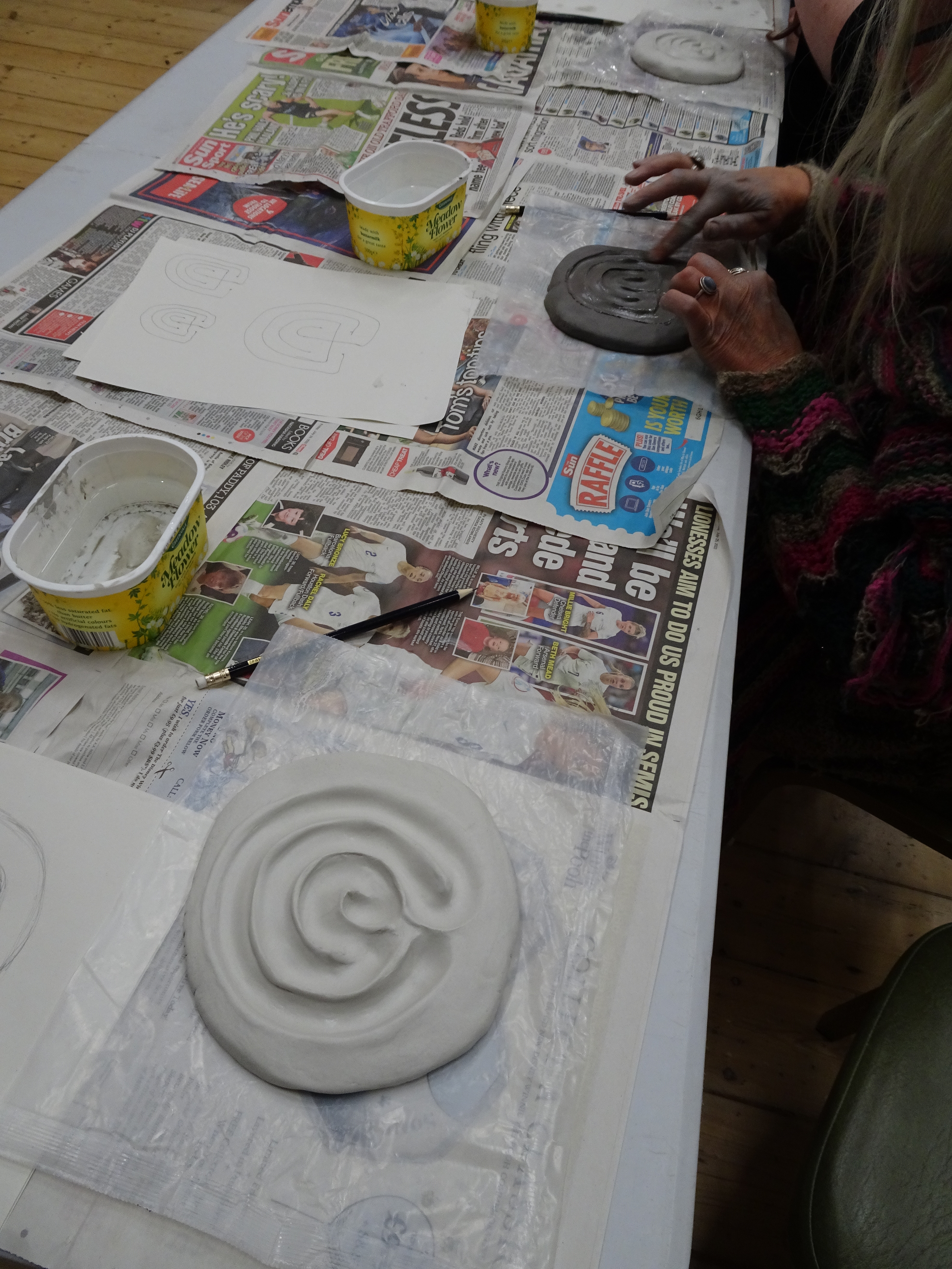 The labyrinth 'work bench: tables with newspaper and plastic, with tubs of water, where people made their labyrinths from air-drying clay.