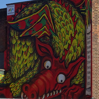 The dragon mural above Red Lion and Rampant Horse Streets, in red and yellow, with big, white eyes and white teeth.