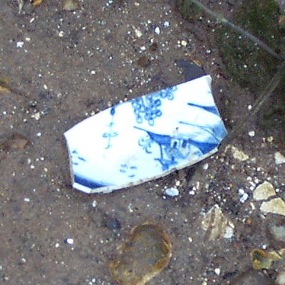 A sherd of Lowestoft blue and white porcelain in the mud of the river Yare.